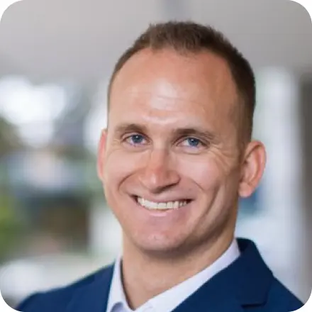 Man with high forehead, light blue eyes and navy jacket