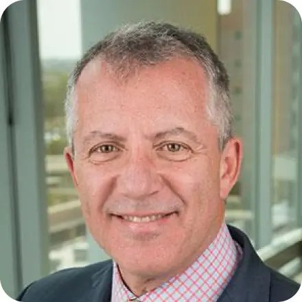 Man with gray hair and light blue shirt with a red windowpane pattern