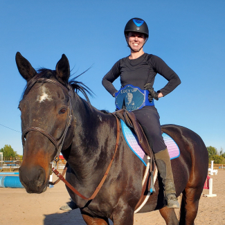 Smiling woman riding a horse