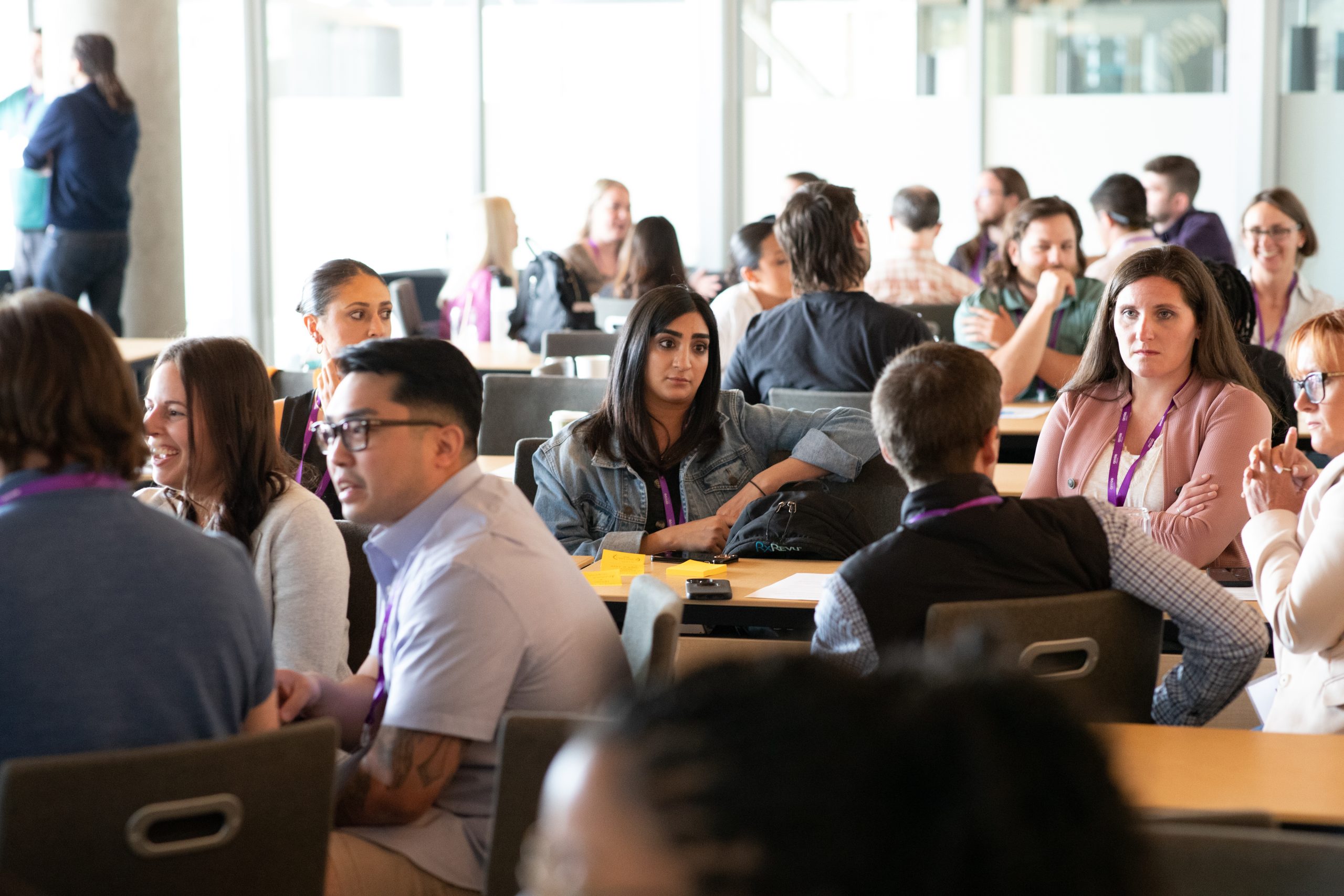 Team members sitting at tables during a large meeting