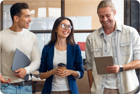 Two men on each side of a woman wearing glasses and holding a coffee cup